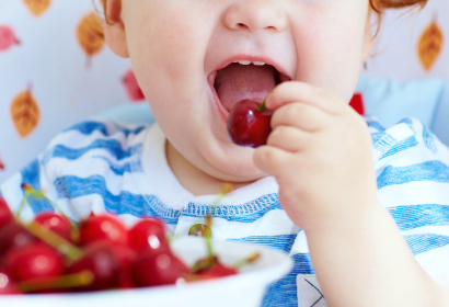 Ребенок ест вишенку