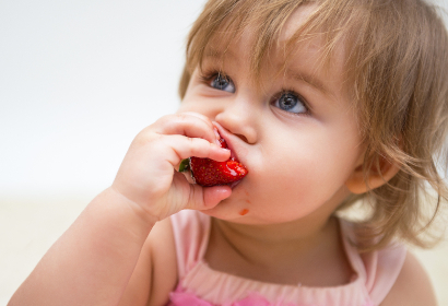 Ребенок ест сочную клубнику