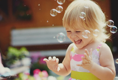 Девочка играет с мыльными пузырями