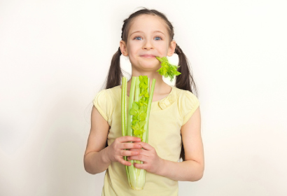 Ребенок ест полезный овощ