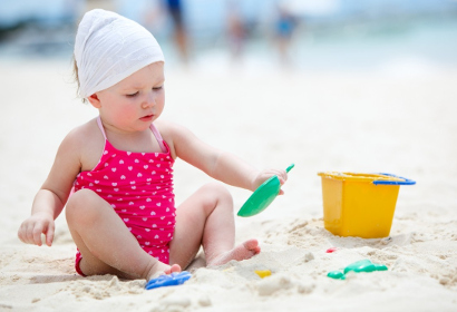 Маленькая девочка играет на пляже
